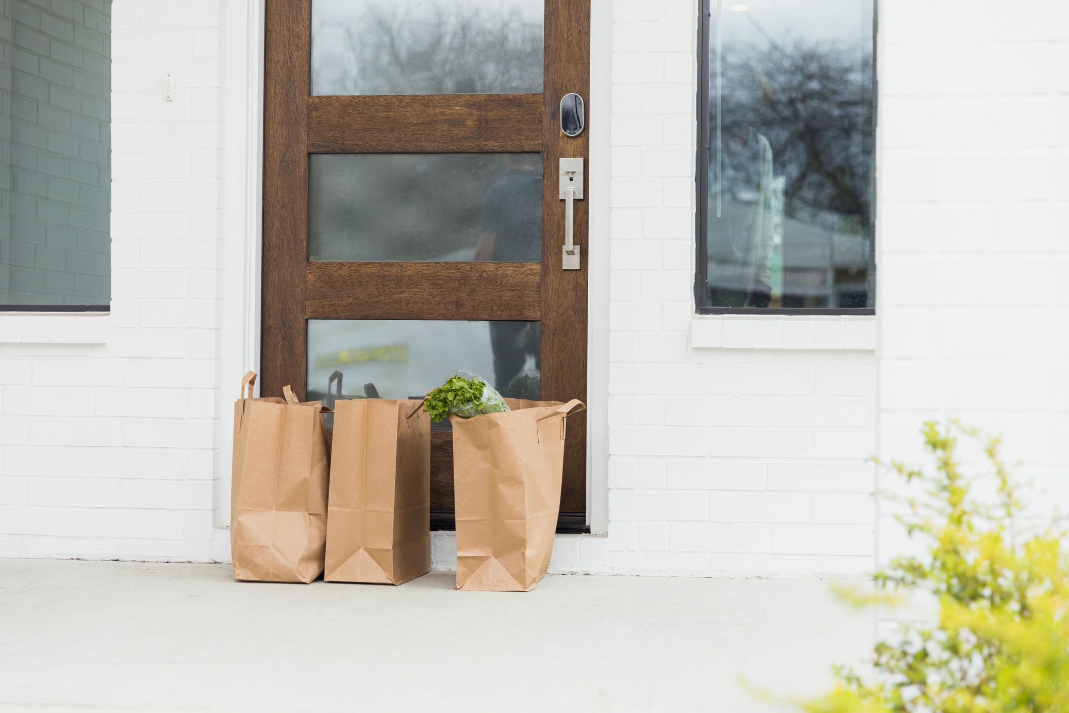 Delivery bags placed at a front door for local drop-off