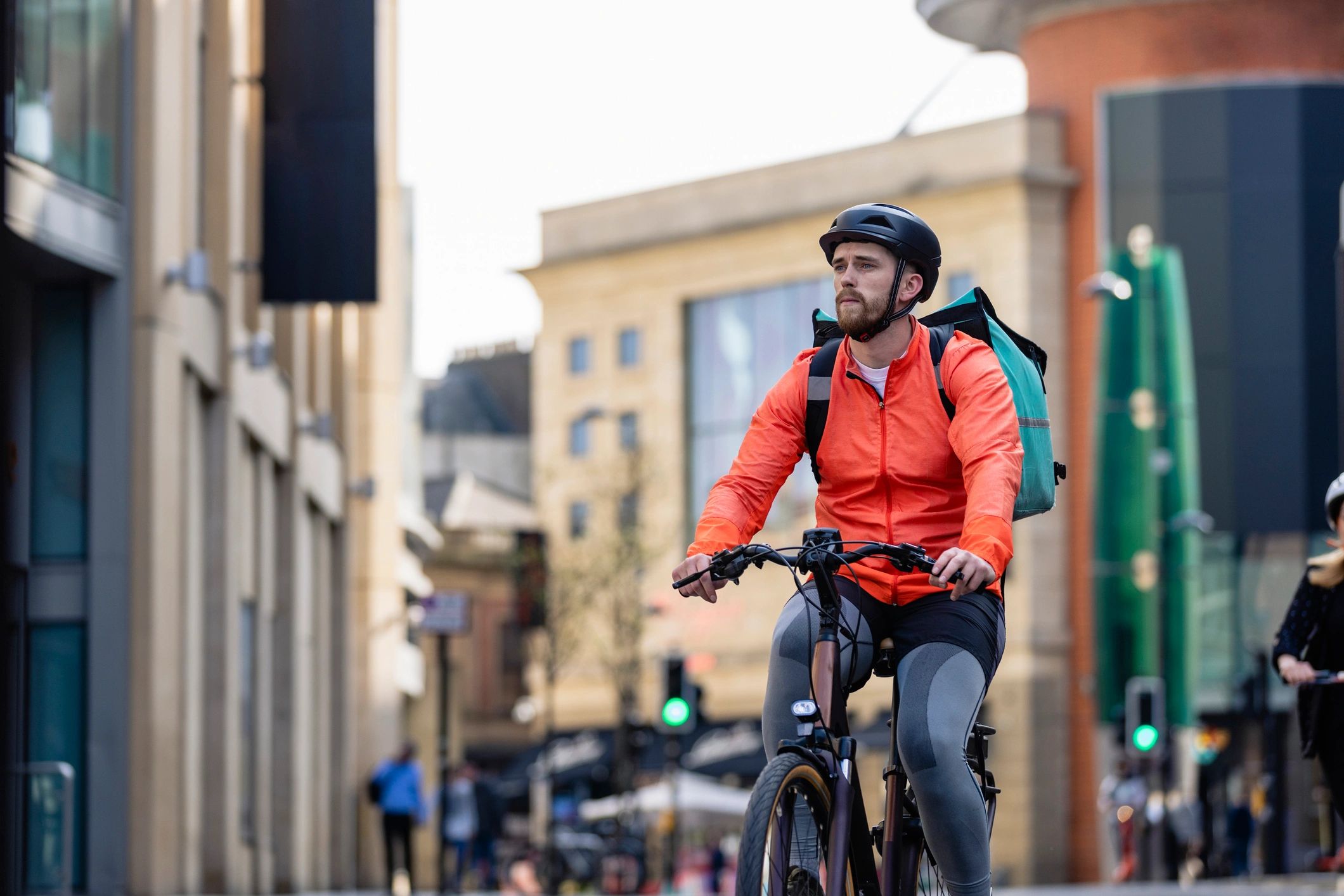 Delivery rider traveling through town with an insulated delivery bag
