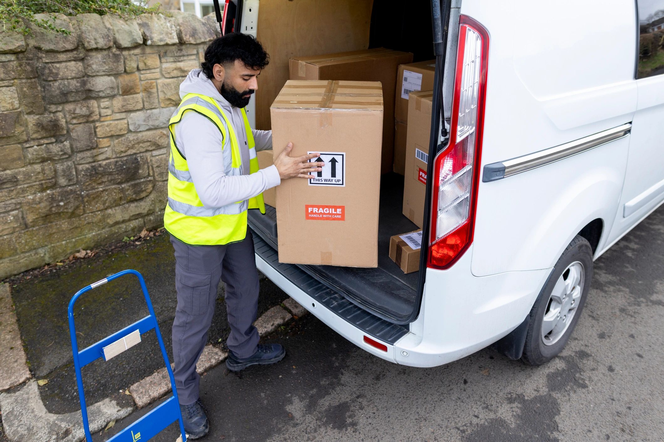 Local courier unloading packages from a delivery van